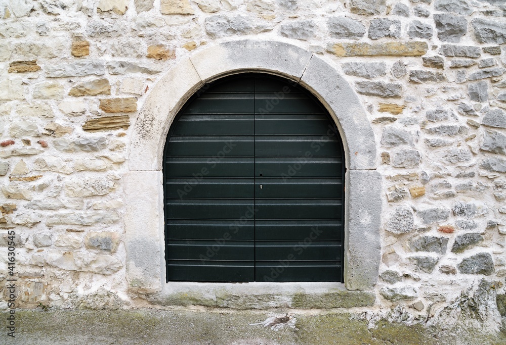 old dark green wooden door on stone wall