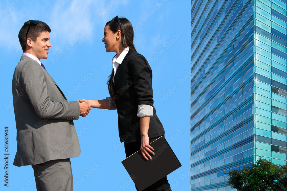 Business couple shaking hands over deal outdoors. Business couple shaking hands over deal outdoors.