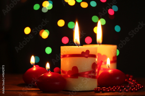 Beautiful candles on wooden table on bright background