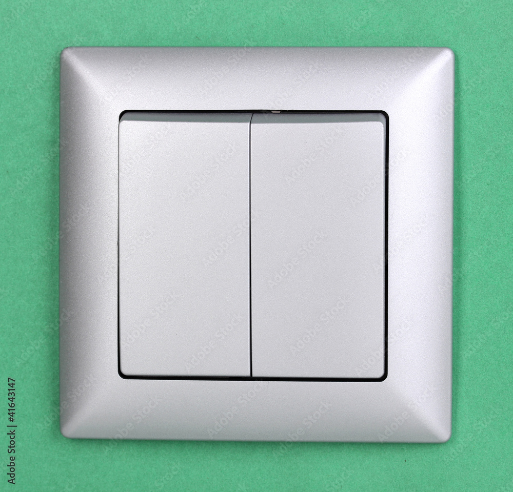 Modern light switch on green background