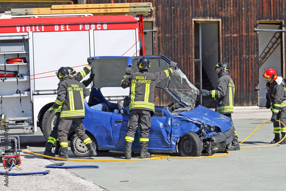 Obraz premium firefighters in action for free from a car, injured in a car acc