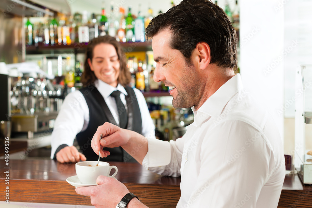 Barista mit Gast in seinem Cafe oder Coffeeshop Barista mit Gast in seinem Cafe oder Coffeeshop