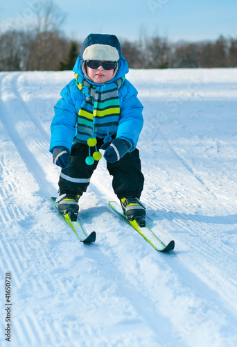 Cute little boy skiing downhill
