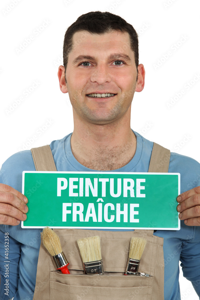 Painter holding a fresh paint sign. Painter holding a fresh paint sign.