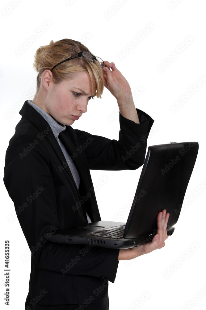 businesswoman with laptop frowning with glasses raised businesswoman with laptop frowning with glasses raised
