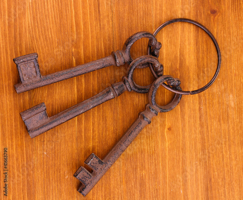 a bunch of antique keys on wooden background