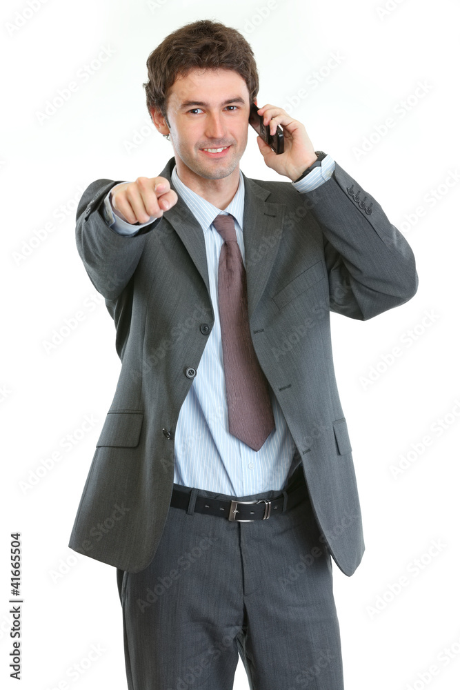 Modern businessman speaking cell phone and pointing on you Modern businessman speaking cell phone and pointing on you