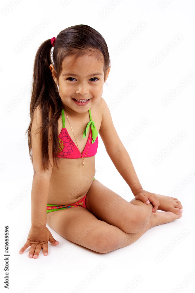 enfant assise en maillot de bain sur fond blanc enfant assise en maillot de bain sur fond blanc