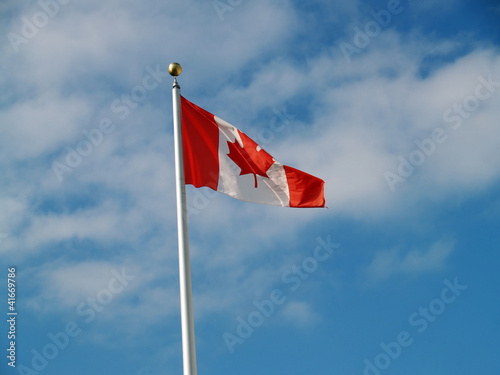 Canadian Flag Flying on Pole Against Sky