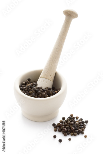 black peppercorns in a white pestle and mortar