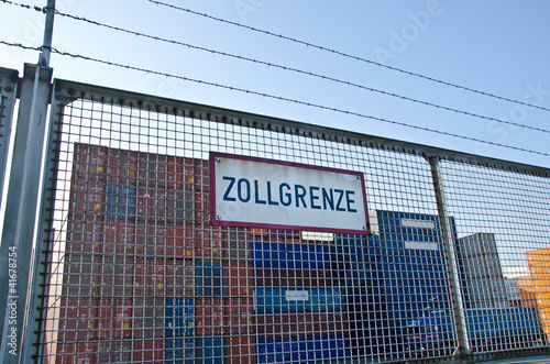 Stacheldraht Zaun mit Schild Zollgrenze vor Container Lagerplatz