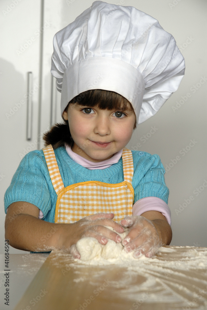 Pequeña niña cocinando pizza,gorro de chef. Stock Photo | Adobe Stock