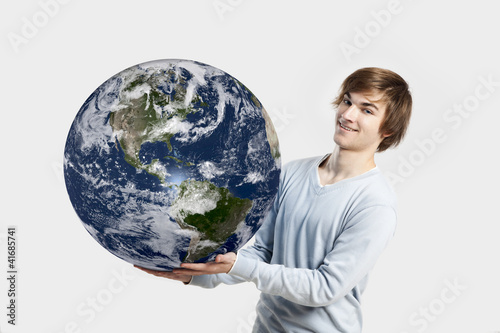Handsome young man holding the planet earth on its hands