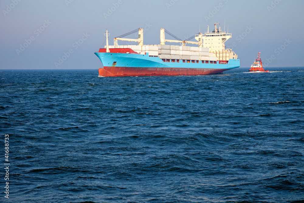 Container ship assist by a tugboat towards the port of Gdansk. Container ship assist by a tugboat towards the port of Gdansk.