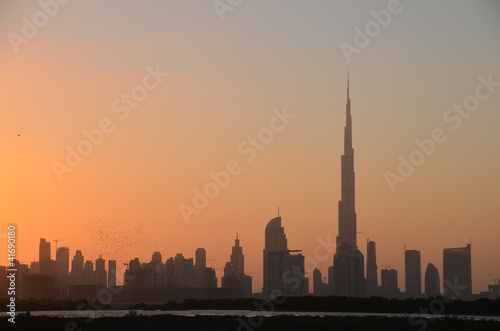Silhouette of Burj Khalifa building and Dubai skyline at sunset