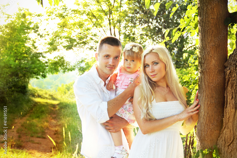 Happy young family with pretty child posing on countryside, out Happy young family with pretty child posing on countryside, out