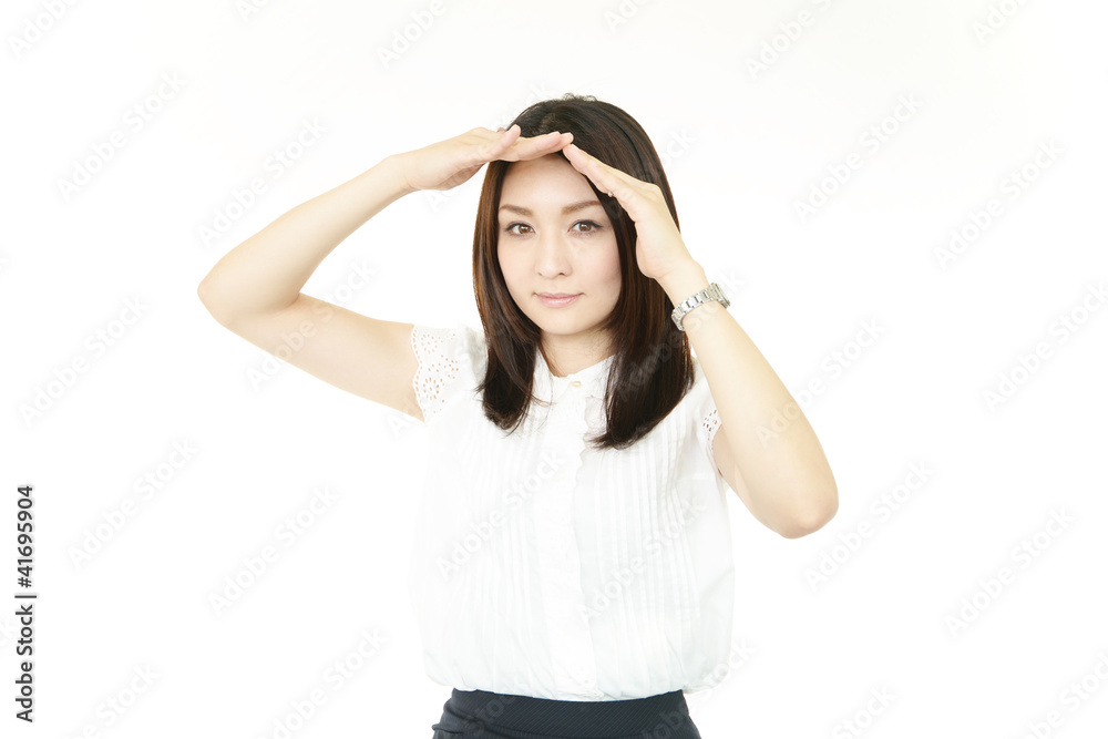 手で日差しをさえぎる女性 手で日差しをさえぎる女性