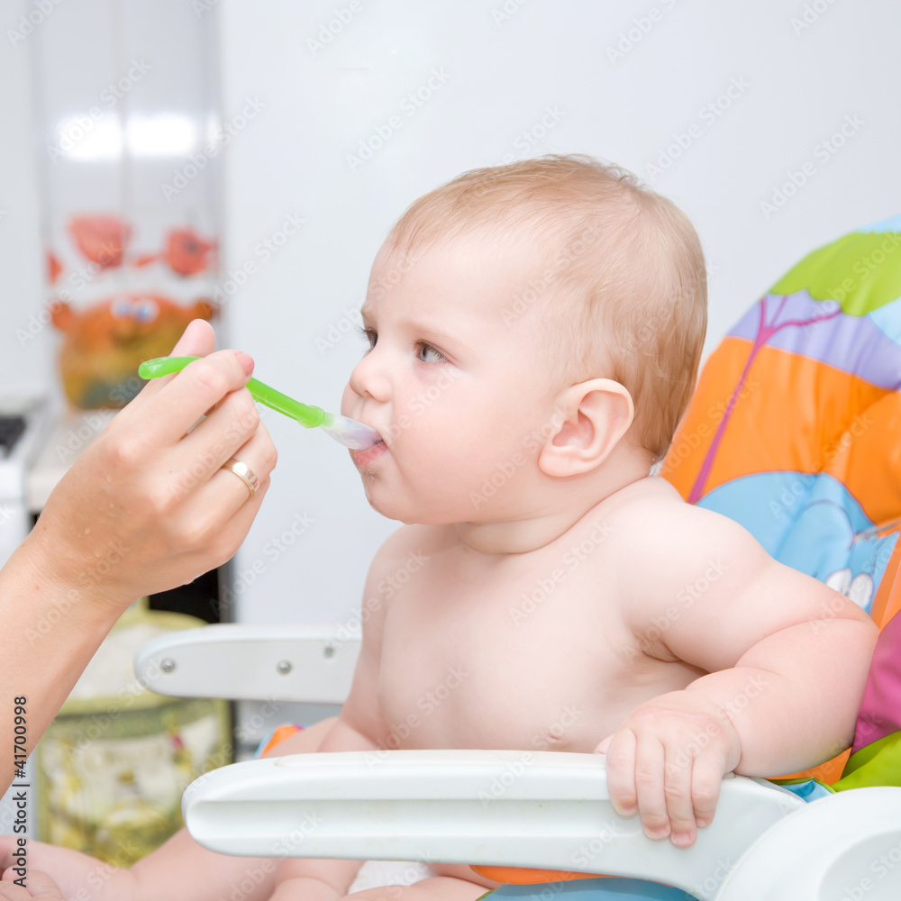 Mother feeding baby food to hungry baby. Mother feeding baby food to hungry baby.