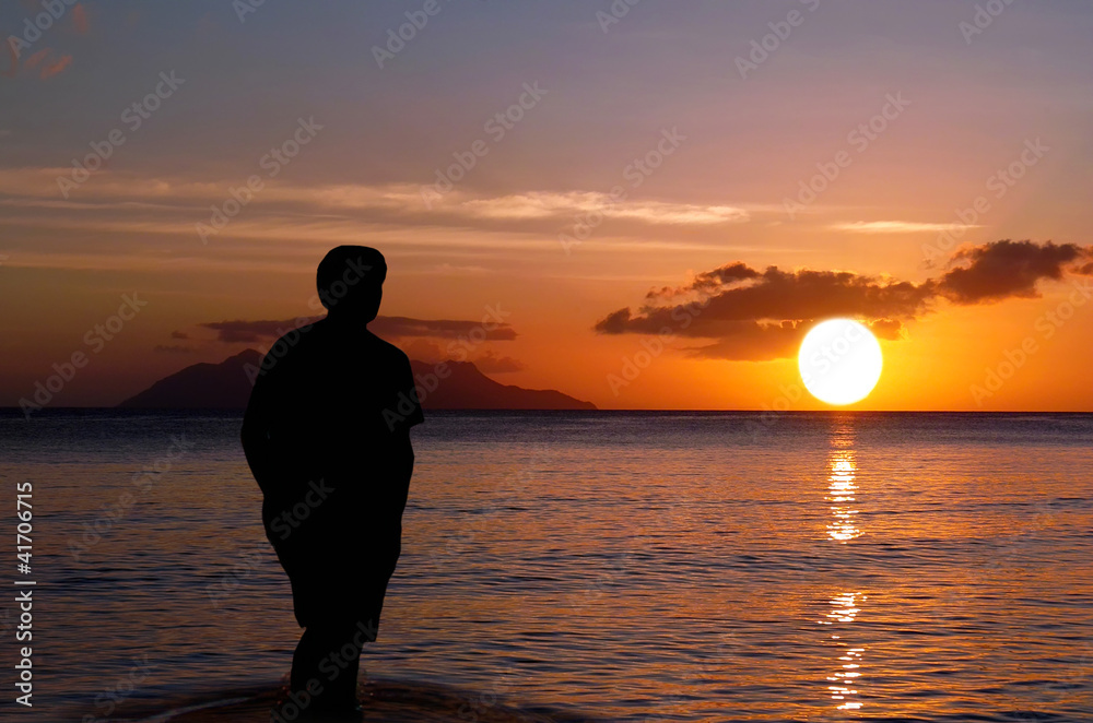 Lone on sunset . Man on paradise sunset beach.