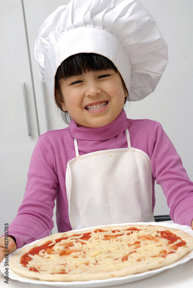 Niña chef sujetando una pizza,cocinando pizza. Niña chef sujetando una pizza,cocinando pizza.