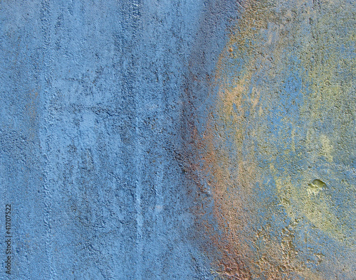 blue grunge wall with yellow and orange paint mark
