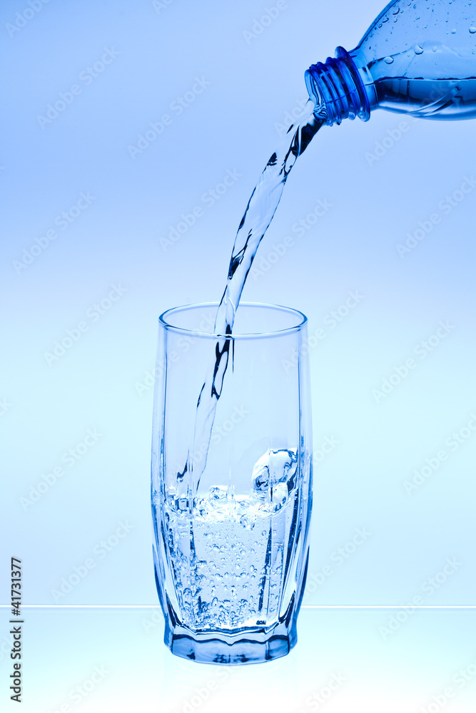 Water flow in a glass from a bottle Water flow in a glass from a bottle