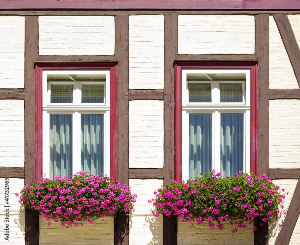Fachwerkfassade mit Fenstern und Blumenkästen