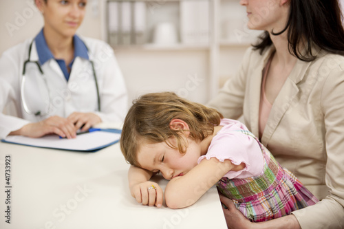 Pediatrician talking to mother and sick child