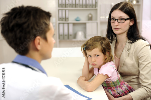 Pediatrician talking to mother and upset child