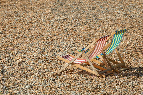 empty deckchairs on a pebbled beach