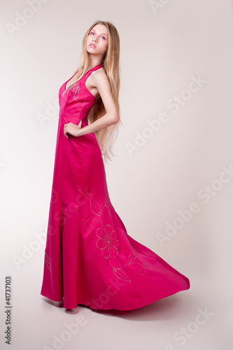 Beautiful young woman wearing a sexy pink evening dress