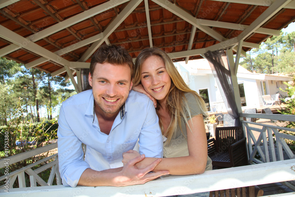 Smiling couple standing in private home gazebo