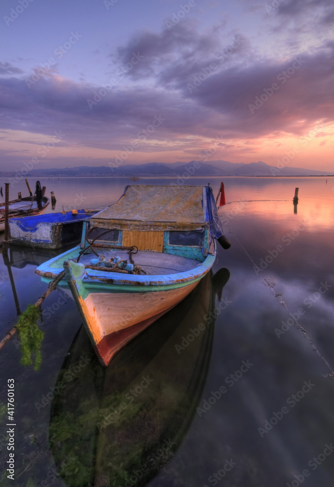 An abondened fishing boat at the setting sun