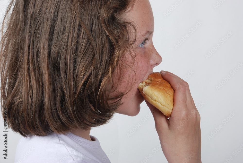 A  young girl eating a bun