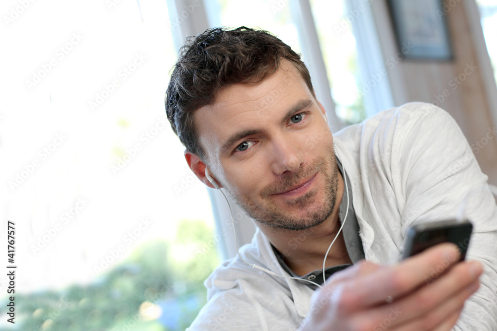 Young man using mobile phone with handsfree headset Young man using mobile phone with handsfree headset