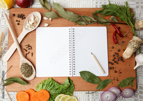 notebook for recipes and spices on wooden board