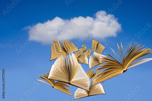 libros volando sobre cielo azul photo