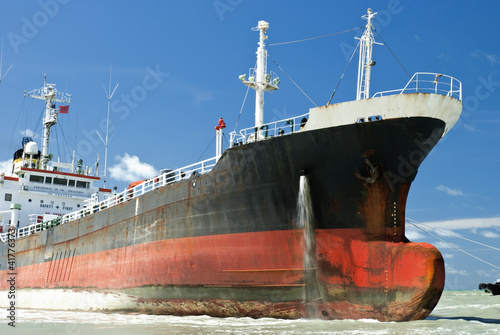 Cargo ship run aground on rocky shore