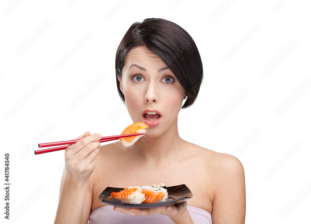 Surprised young woman holding sushi with a chopsticks Surprised young woman holding sushi with a chopsticks