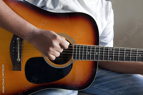closeup view of right hand strumming an acoustic guitar