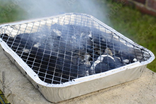 Empty disposable foil BBQ with charchoal.