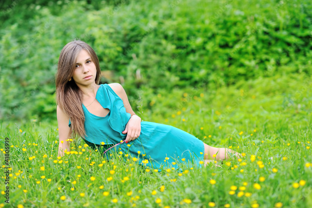 Young cute girl lying in grass near the open space Young cute girl lying in grass near the open space