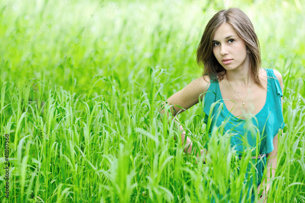 Young beautiful girl in the green grass
