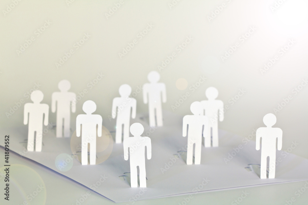 close up of people cut out of paper on table close up of people cut out of paper on table