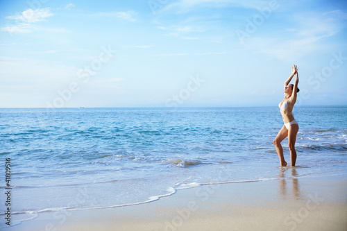 Young woman on a beach doing yoga © Mila Supinskaya 