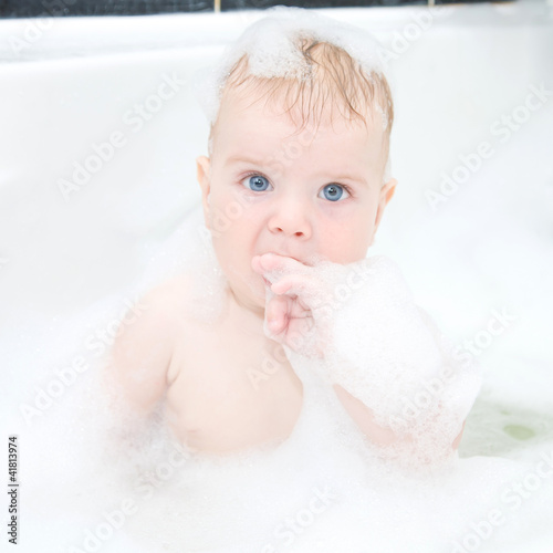 Cute baby boy washing hair hair and body in bath