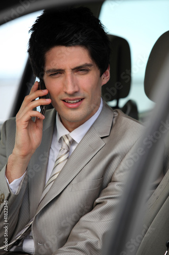 Businessman making call from parked car