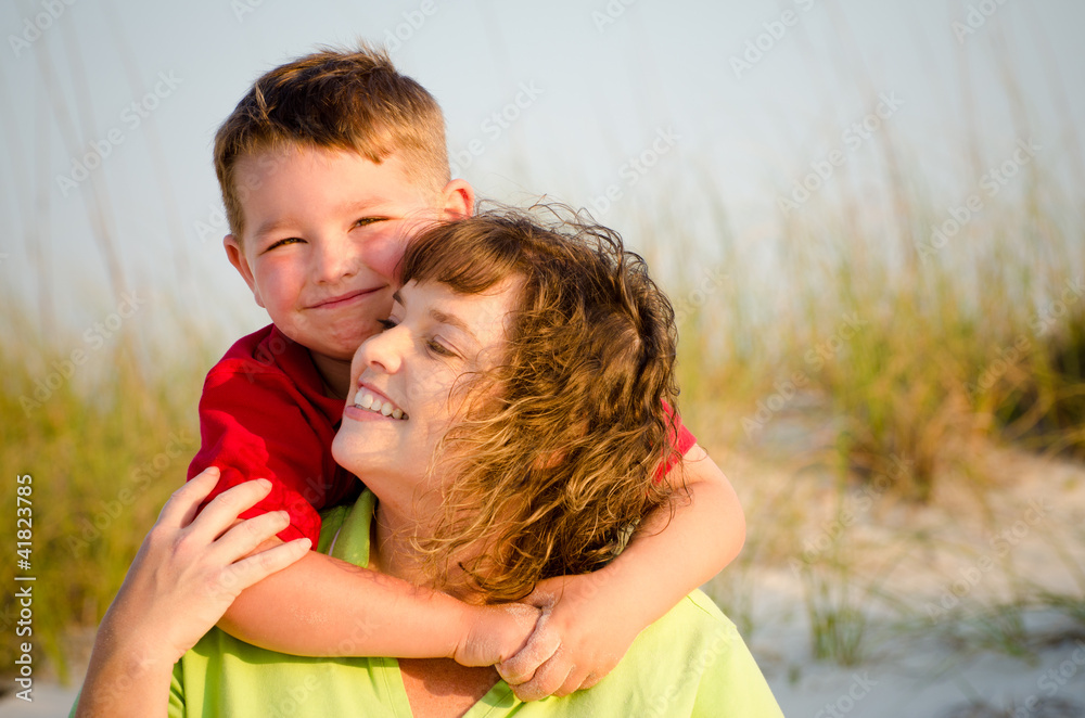 Portrait of happy mother and son hugging at beach Portrait of happy mother and son hugging at beach