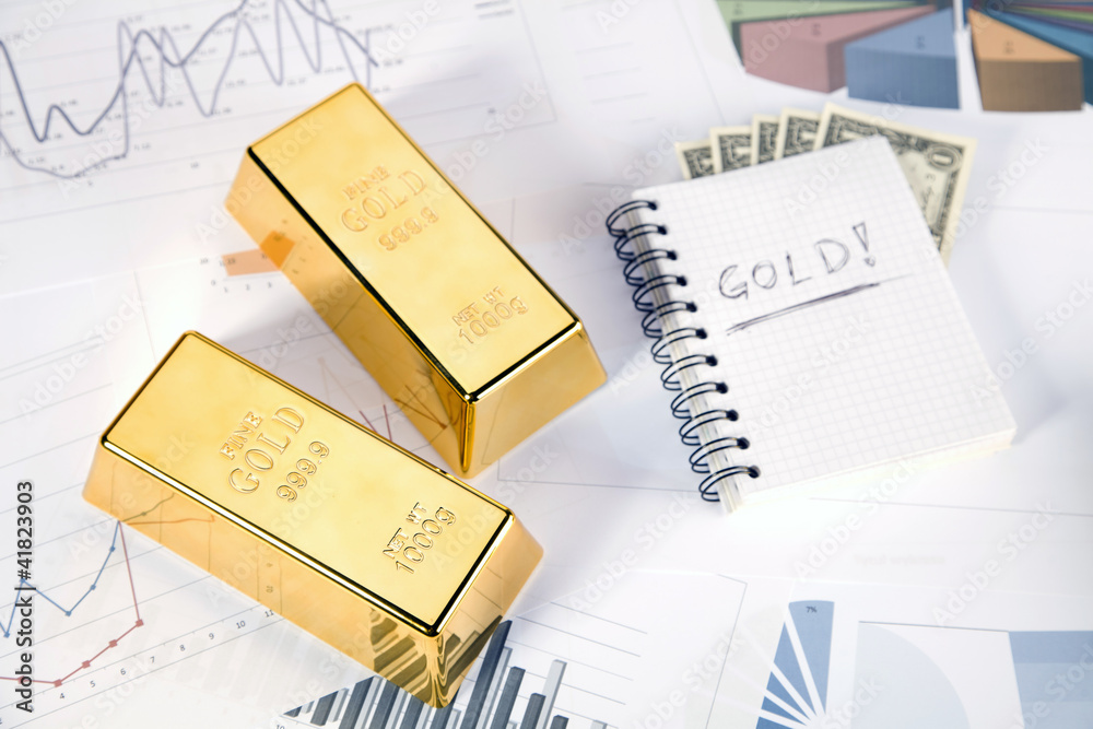 Gold bars on graphs and statistics, studio shots, closeup Gold bars on graphs and statistics, studio shots, closeup
