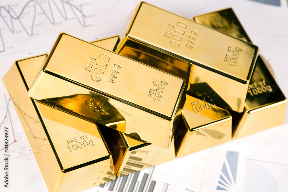 Gold bars on graphs and statistics, studio shots, closeup Gold bars on graphs and statistics, studio shots, closeup